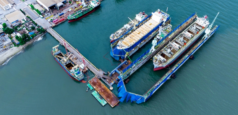 Industriehafen mit vor Anker liegenden Schiffen, der den Seetransport und die Logistik präsentiert.