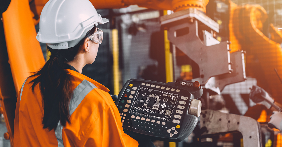 Produktionsmitarbeiterin bedient Roboterarm